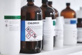 A bottle of chloride is sitting on a shelf next to other bottles.