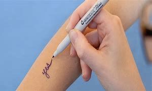 A person is writing on their arm with a marker.
