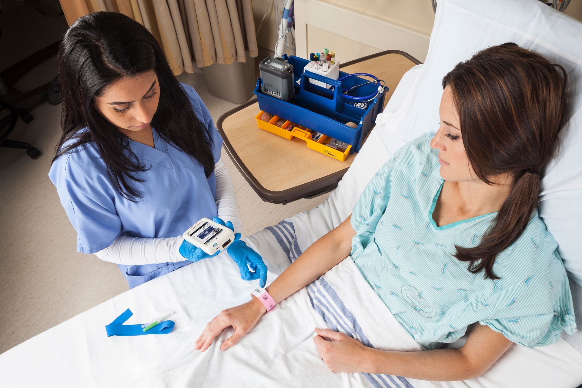 A nurse is giving an injection to a patient in a hospital bed.