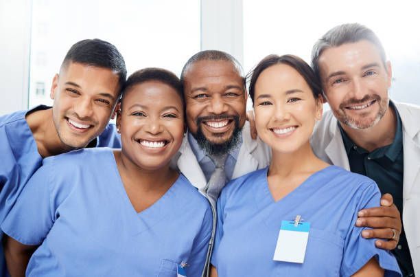 A group of doctors and nurses are posing for a picture together.