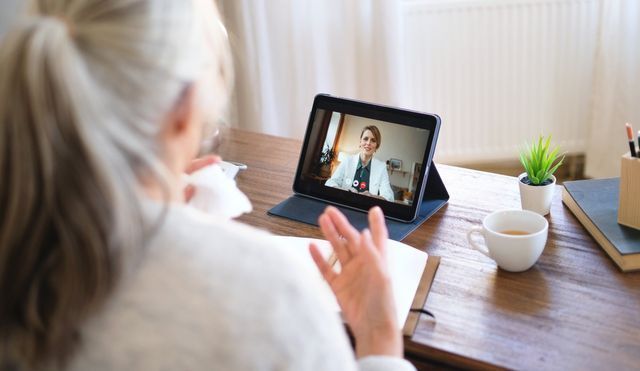 a woman is having a video call with a doctor on a tablet .