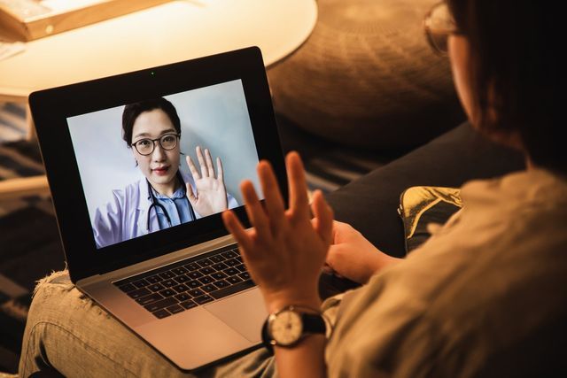 a woman is having a video call with a doctor on her laptop