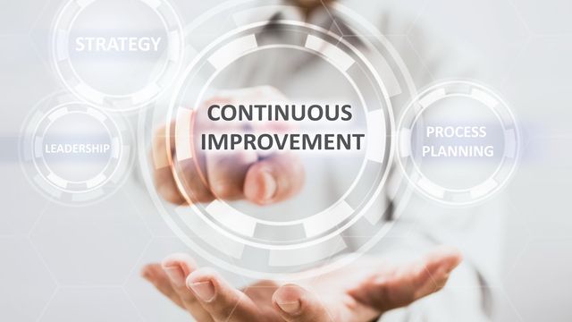 a person is holding a virtual screen that says continuous improvement .