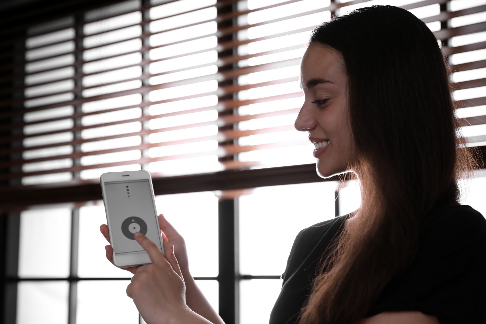 woman pushing button for automated blinds