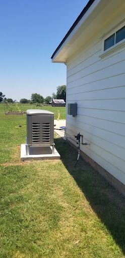 A white house with a generator on the side of it.