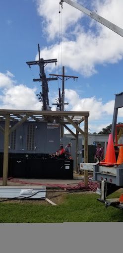 A crane is lifting a wooden structure in a parking lot.
