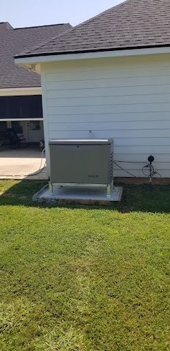 A generator is sitting in the backyard of a house.