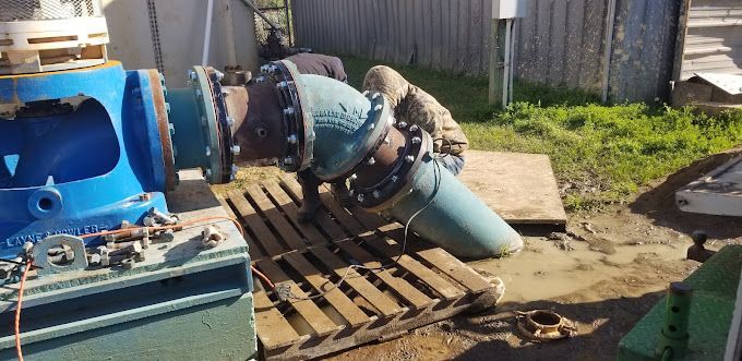 A blue pipe is sitting on top of a wooden pallet.