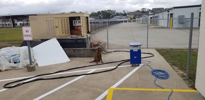 A hose is connected to a machine in a parking lot.