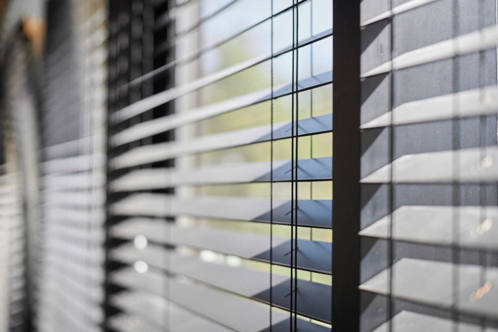Office Blinds With Sunlight Casting Striped Shadows Across a Window — Another Blind Man in Caloundra, QLD