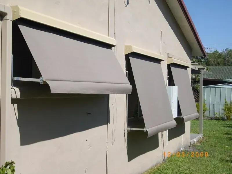 House Exterior With Three Grey Awnings Covering Windows on a Beige Wall — Another Blind Man in Tewantin, QLD
