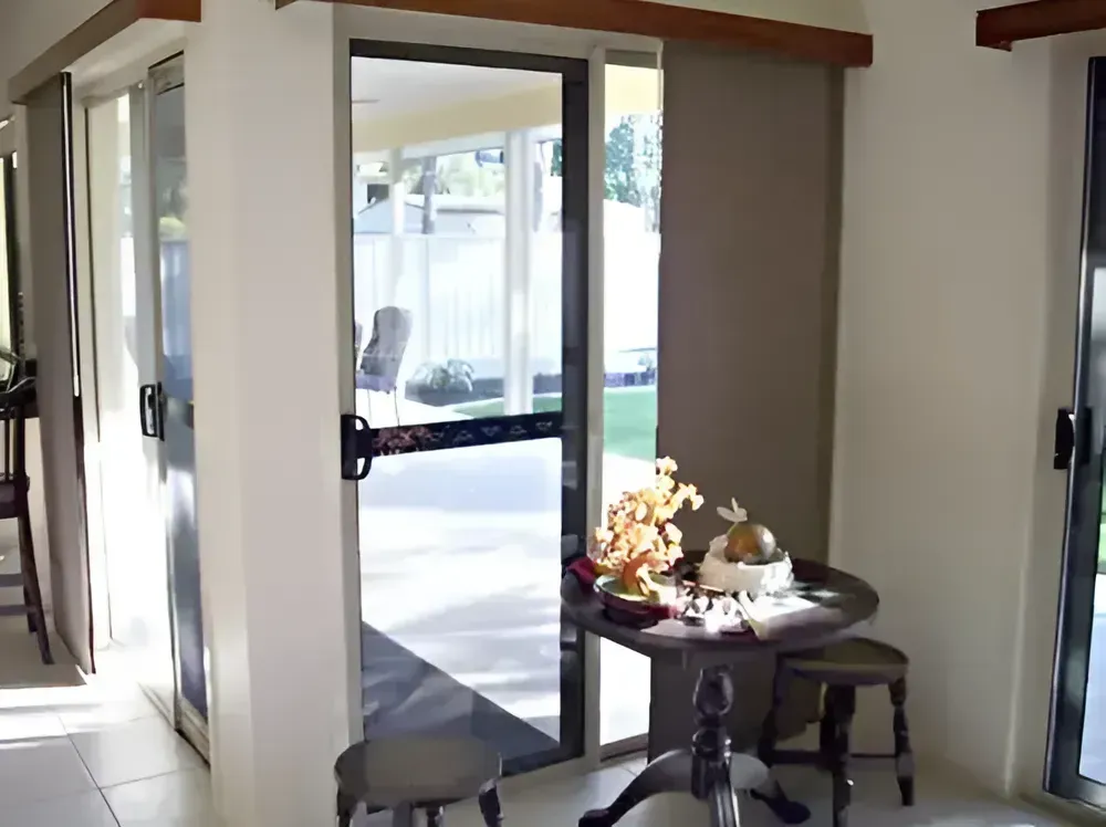 Interior Doorway With Open Glass Door and Small Table by a Patio View — Another Blind Man in Tewantin, QLD
