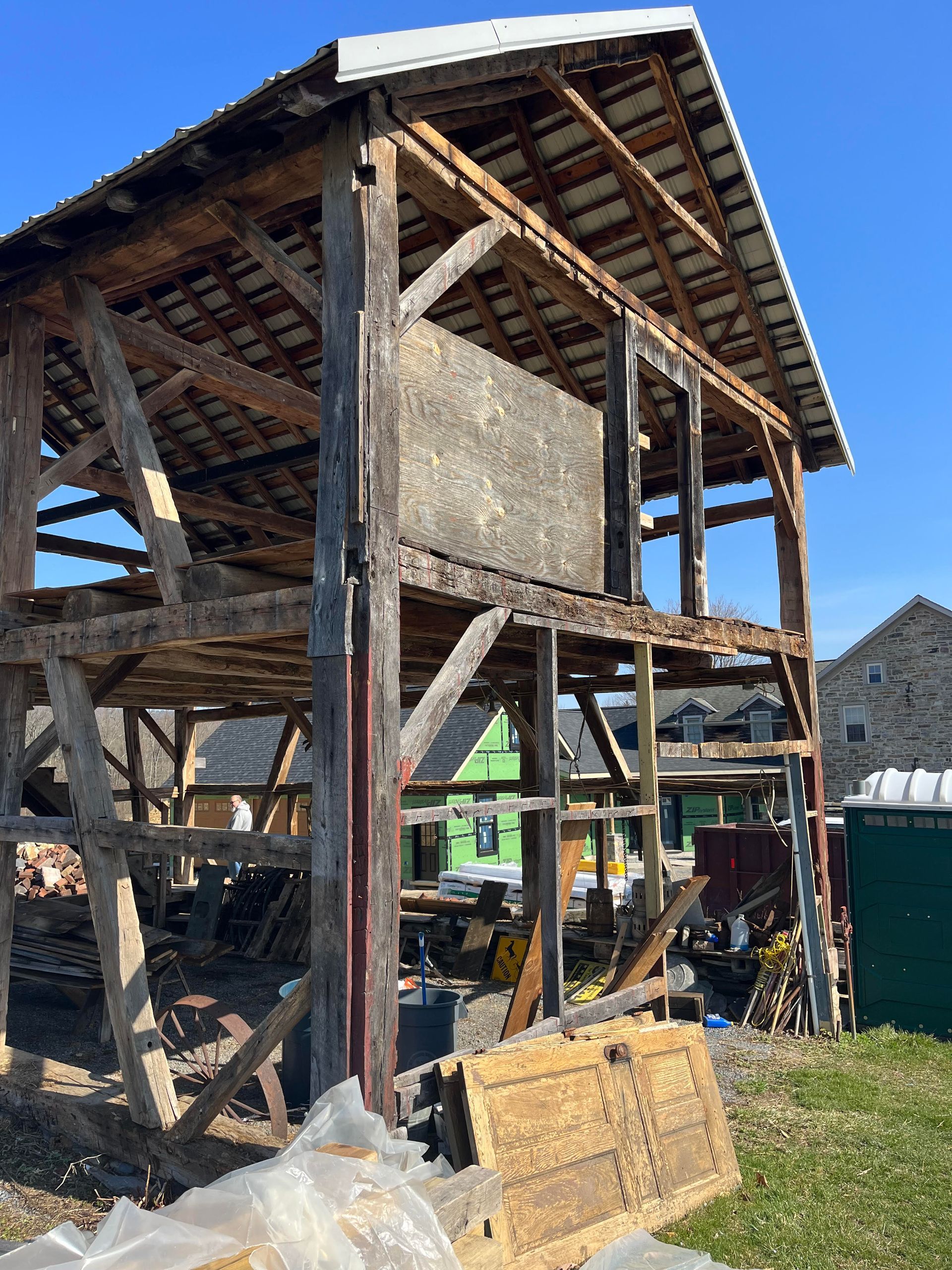 Timber-framed structure under renovation, showing exposed parts of a barn.