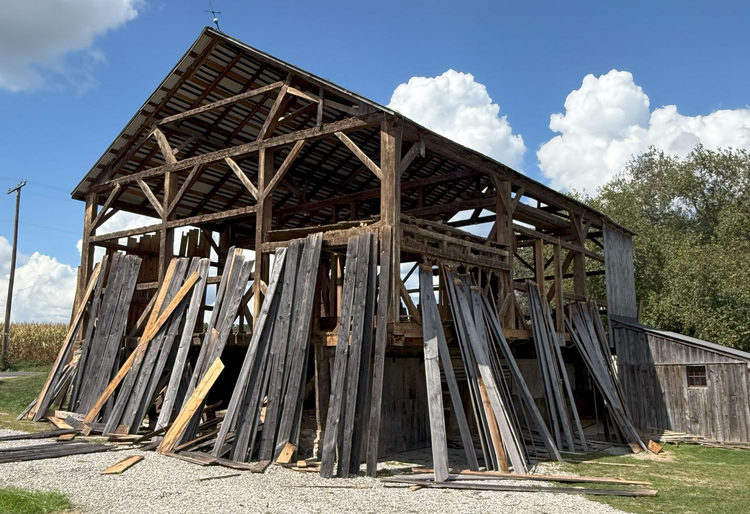 Partially deconstructed barn with weathered wood and exposed beams to be used for architectural salvage projects.
