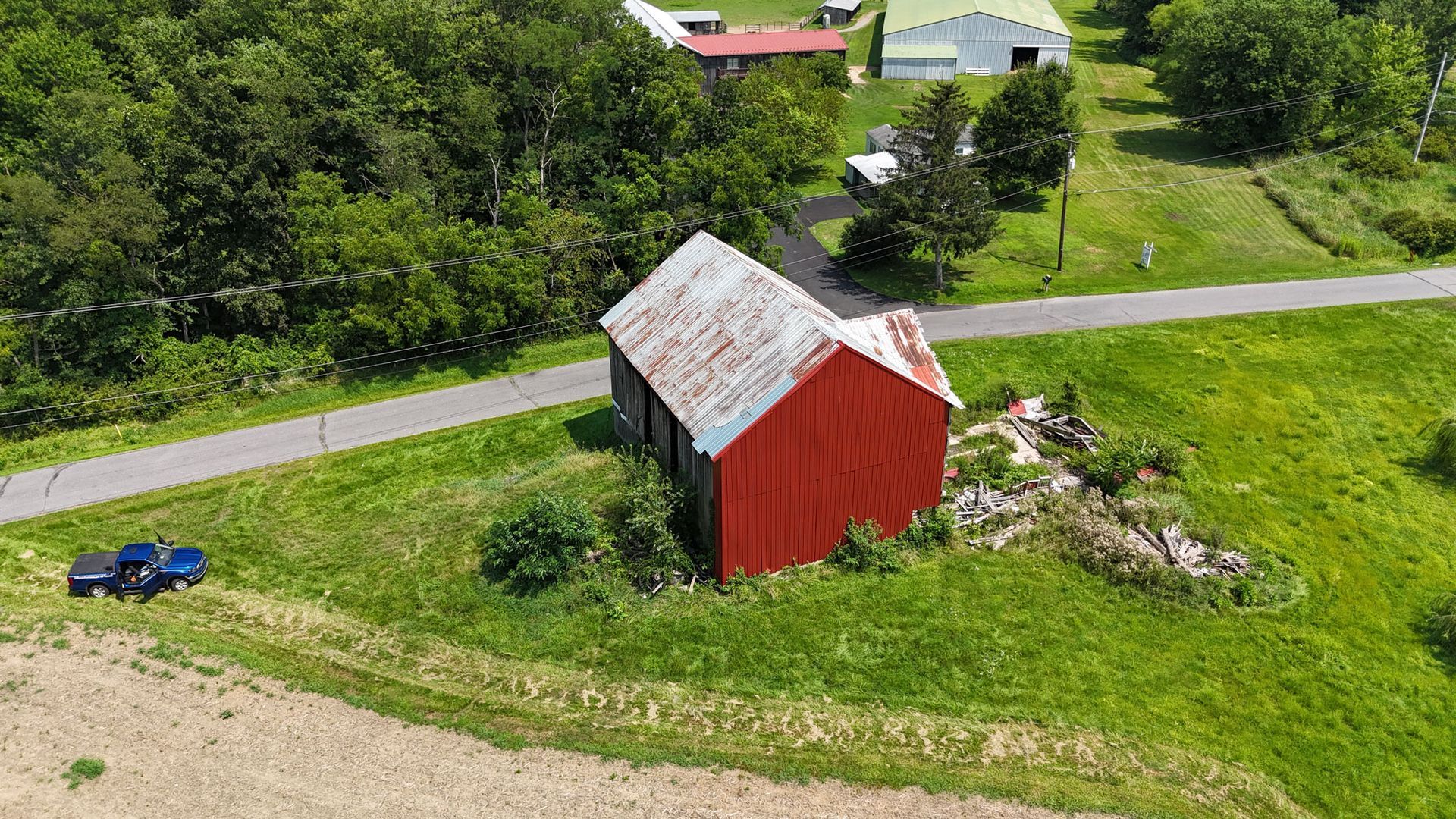 Aerial view of a red barn and rural landscape, ideal for barn kits inspiration.