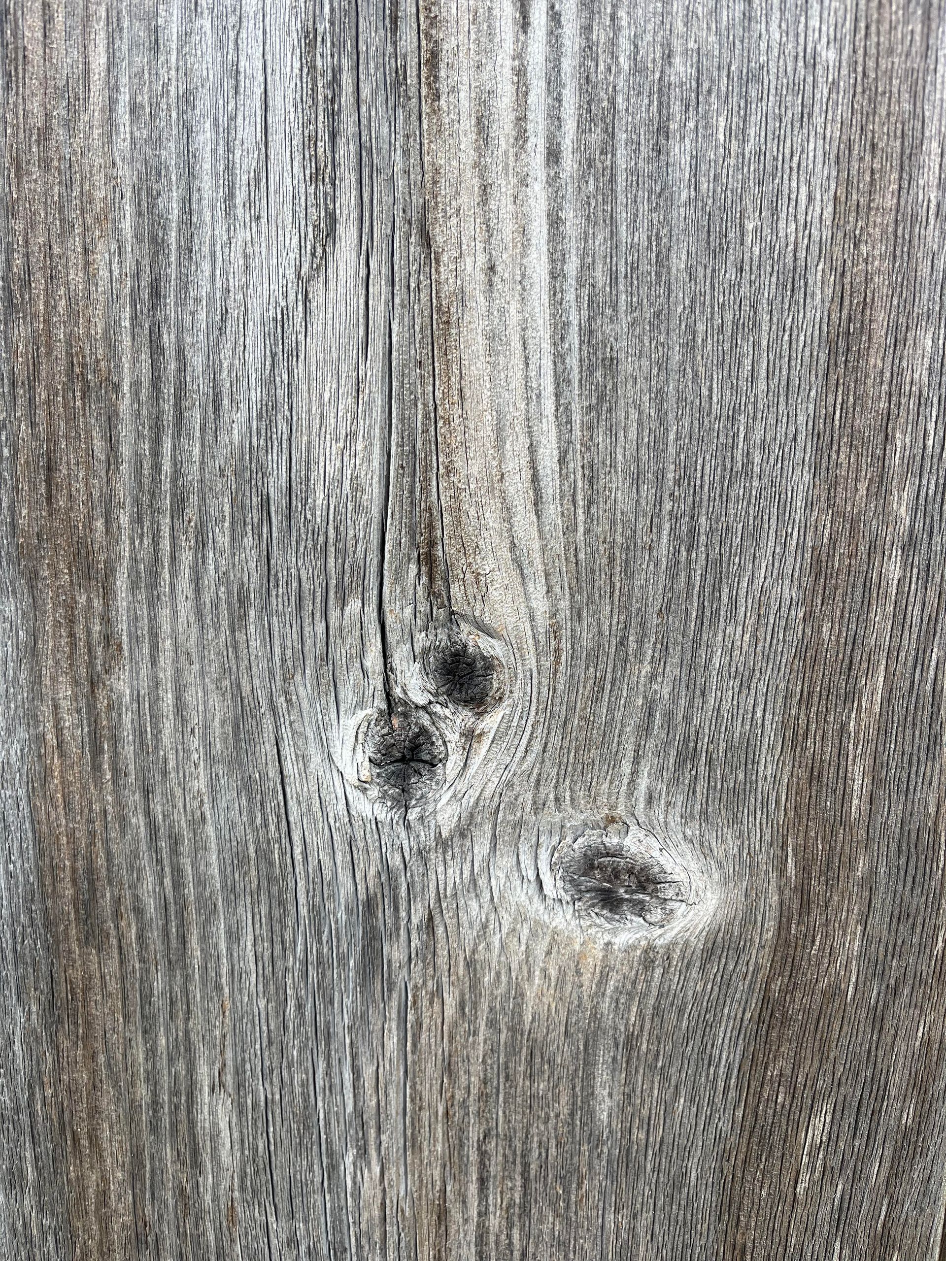 Weathered wood grain with dark wood knots.