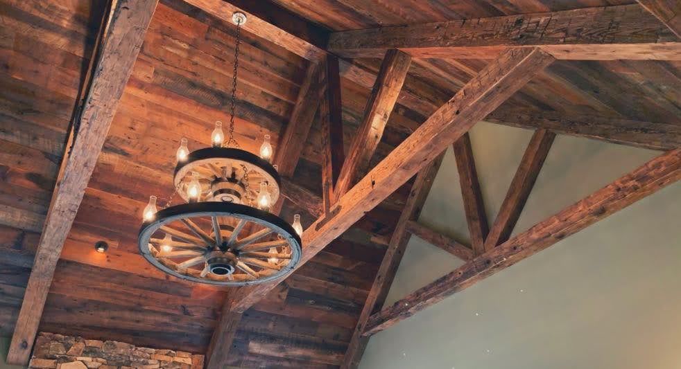 Rustic chandelier and wooden beams showcasing timber frame benefits.