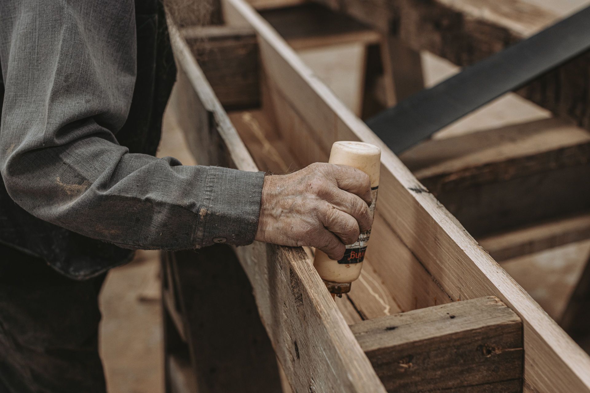 Applying glue to a joint in reclaimed wood construction.