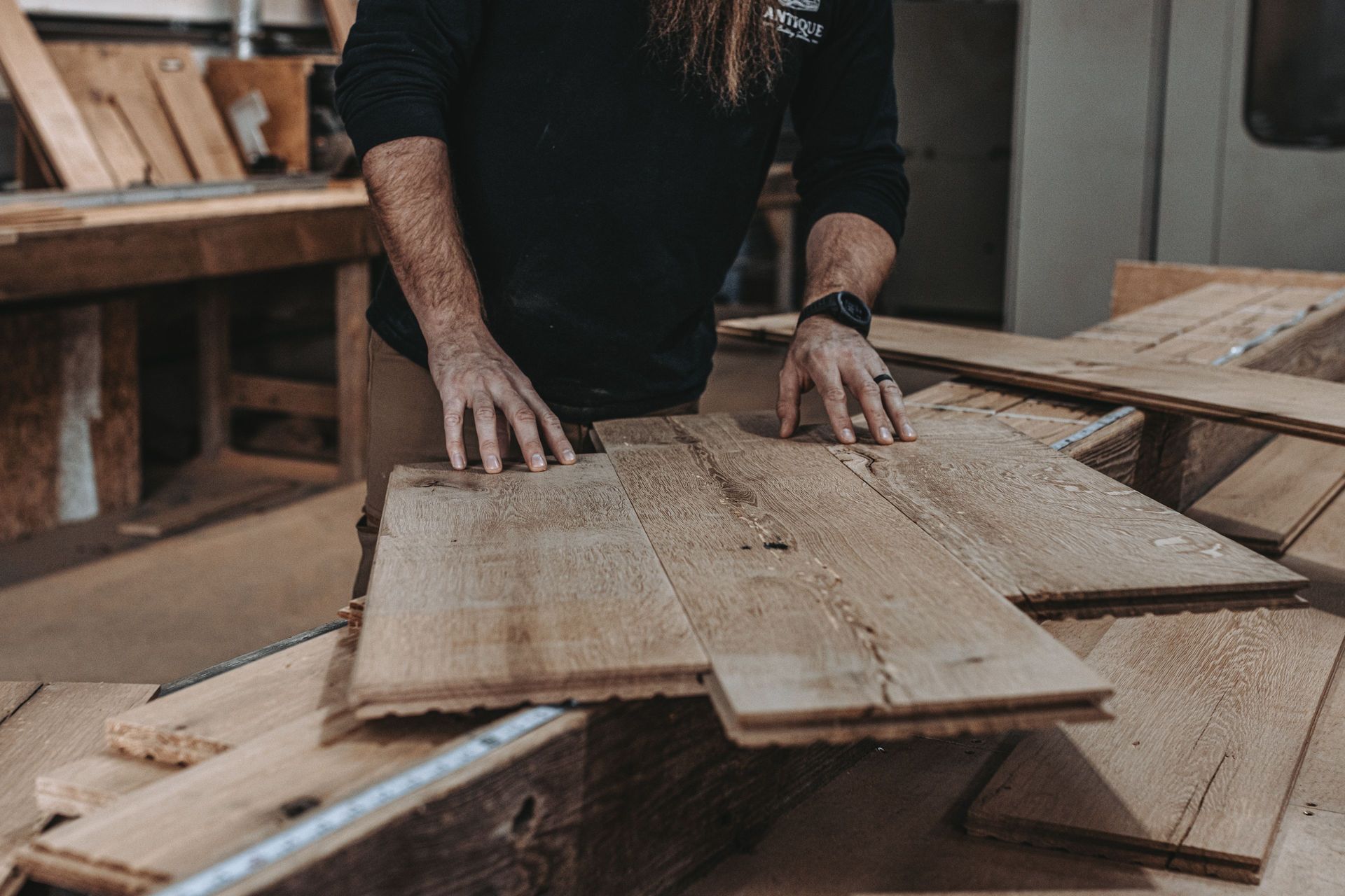 Craftsman inspecting sustainable building materials in a workshop.