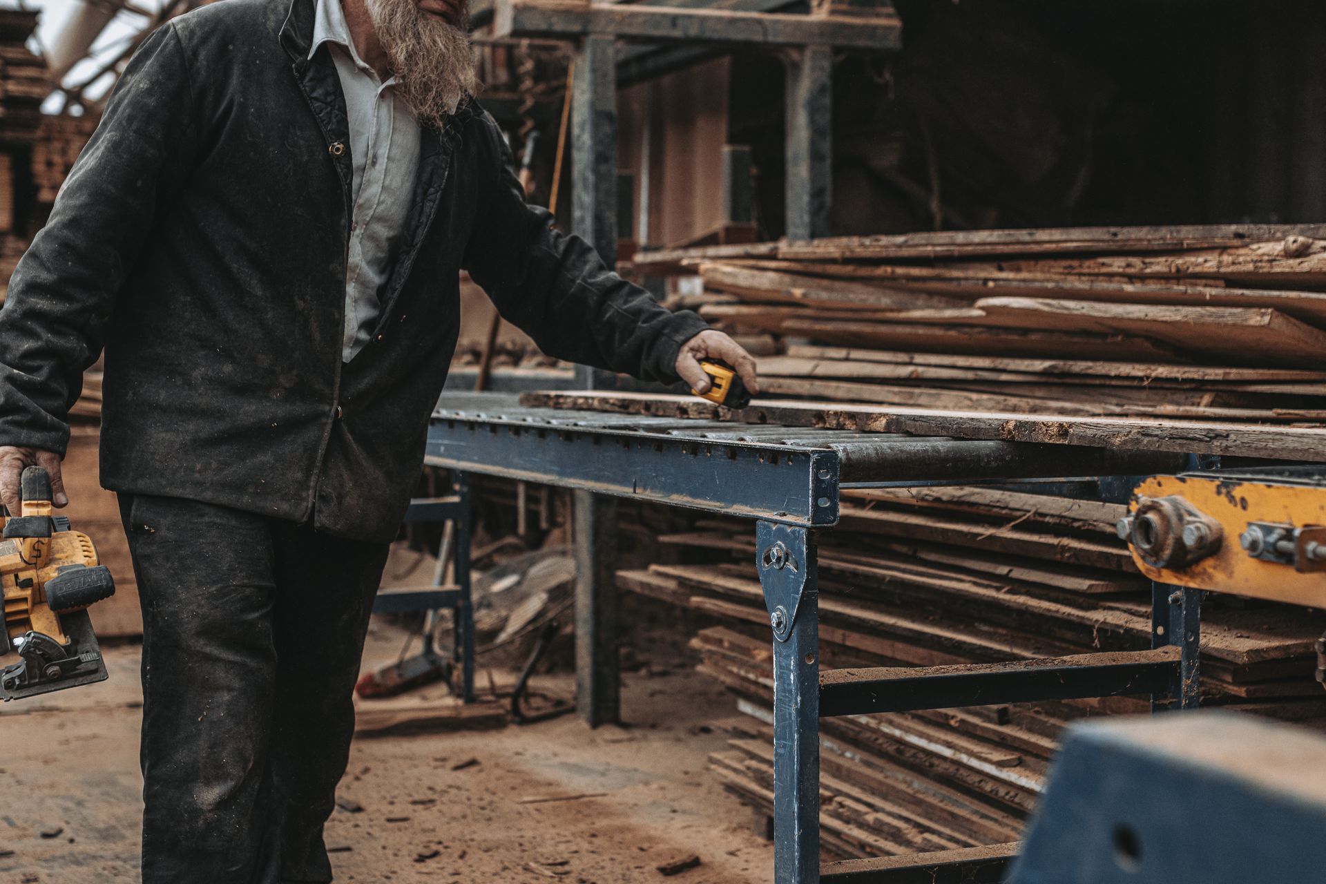 Worker measuring reclaimed wood planks in a Pennsylvania workshop