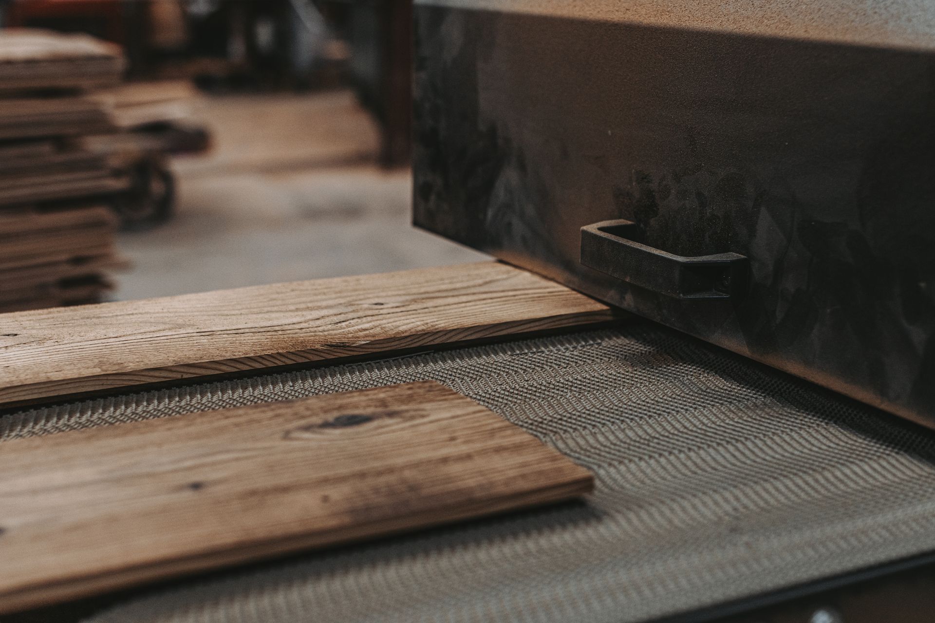 Wood planks on conveyor in Pennsylvania with wood filler applied to smooth surfaces for finishing. 