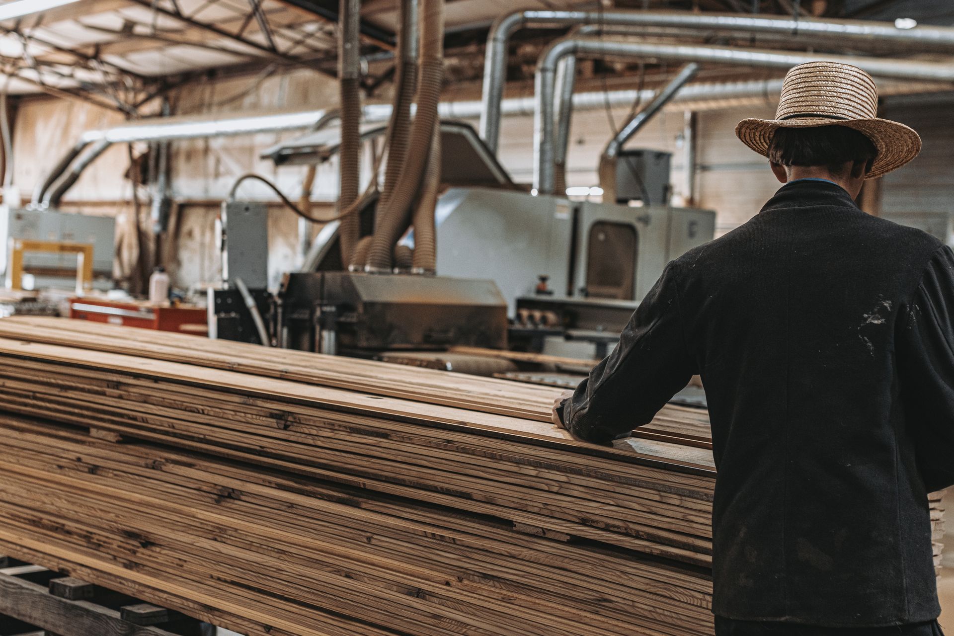 Worker in a factory processing wood for green building techniques.