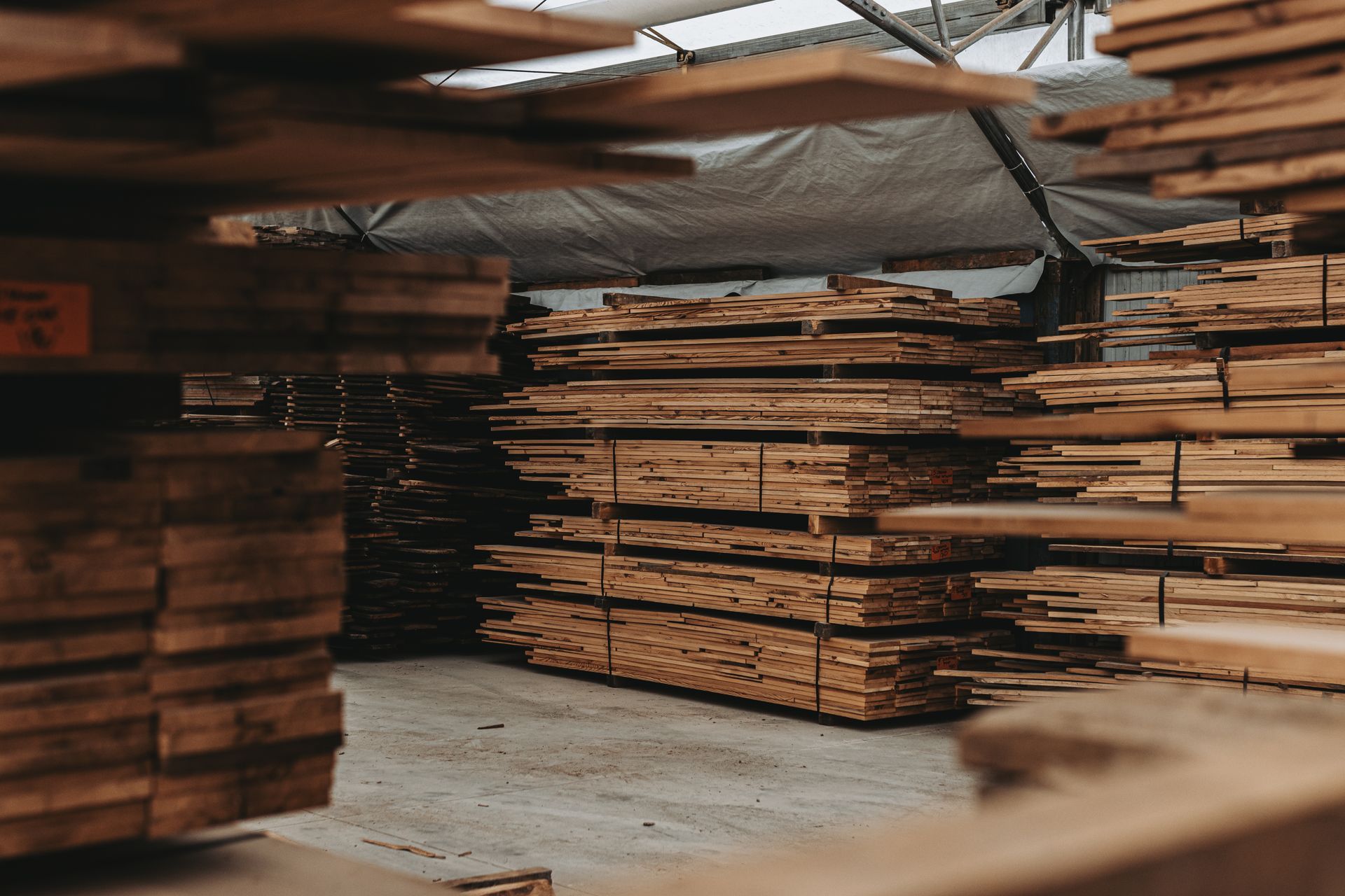 A warehouse filled with lots of wooden boards stacked on top of each other.