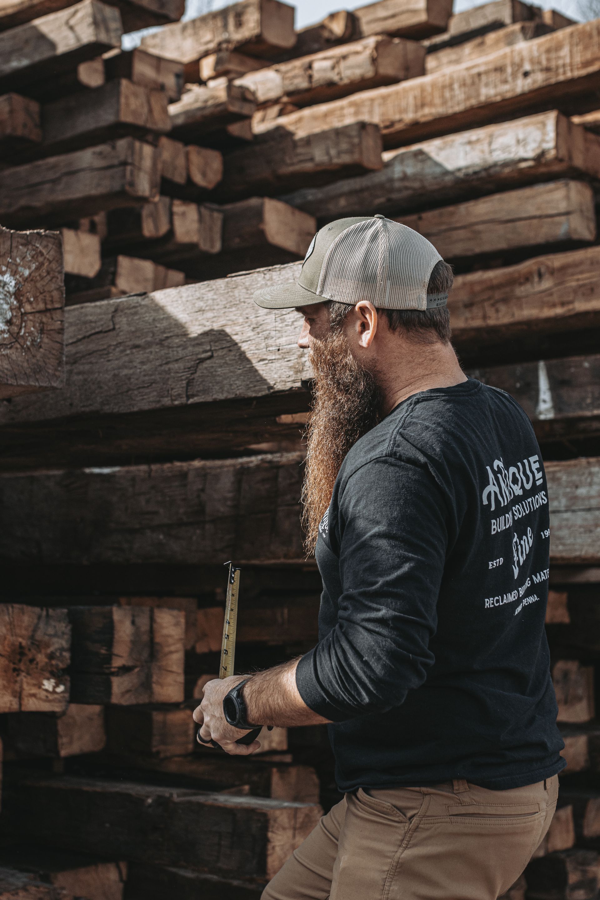 Craftsman measuring wooden beams for structural assessments.