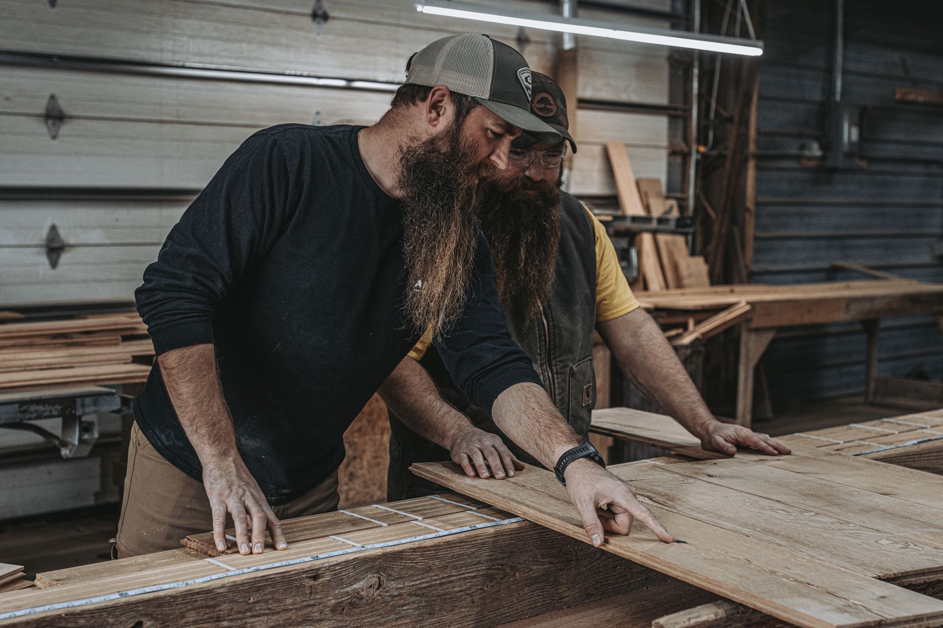Two heritage building consultants inspecting restored barn timber frames.