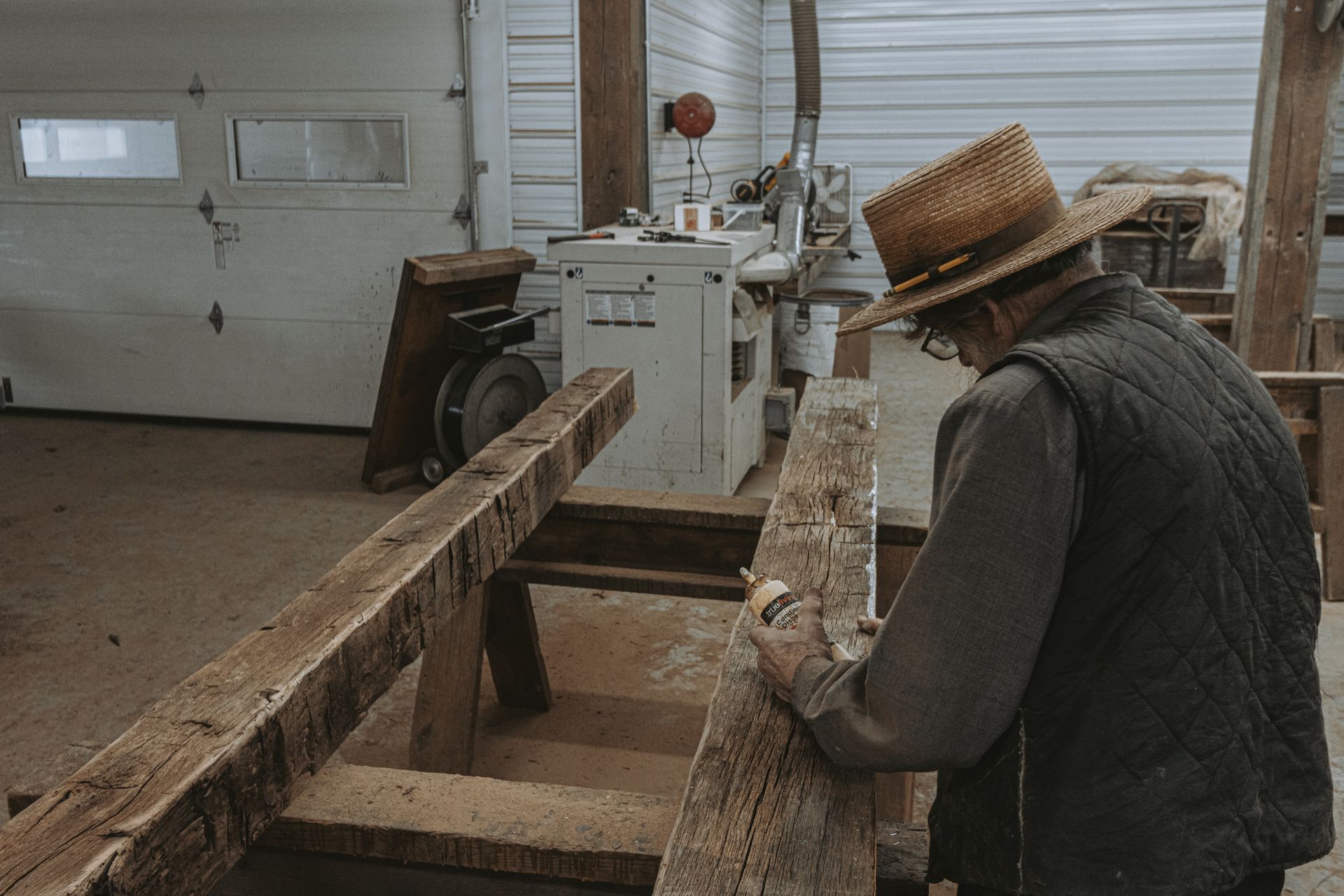 A woodworker repairing a historic timber frame in a workshop.