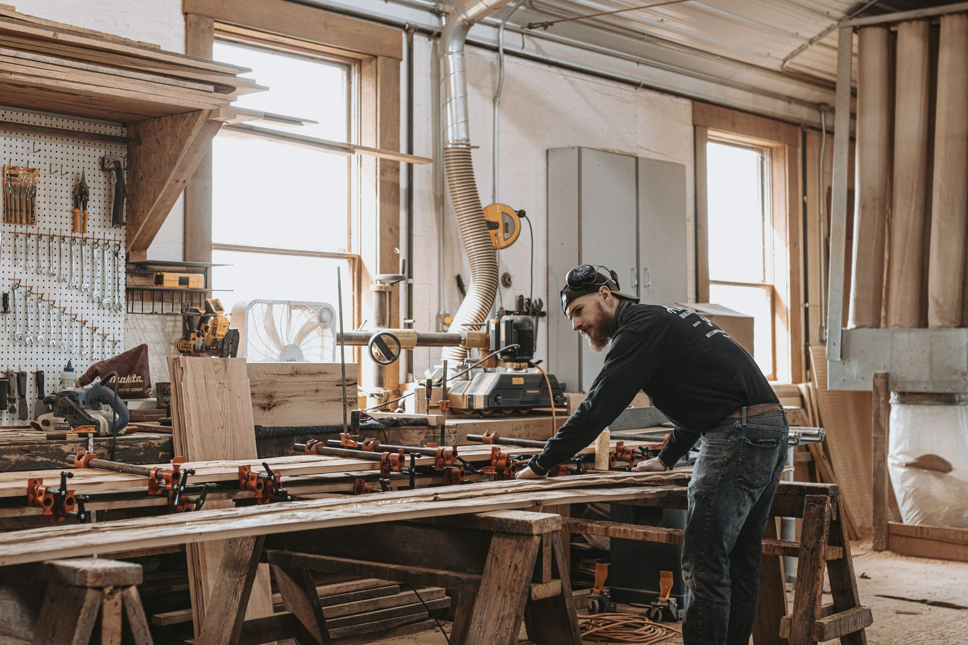 A man is working on a piece of reclaimed lumber in a State College woodworking shop.