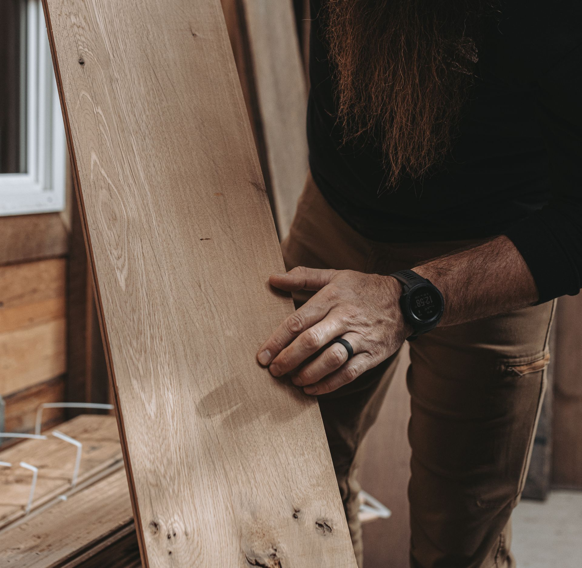 Hand pointing a wooden board's face grain.