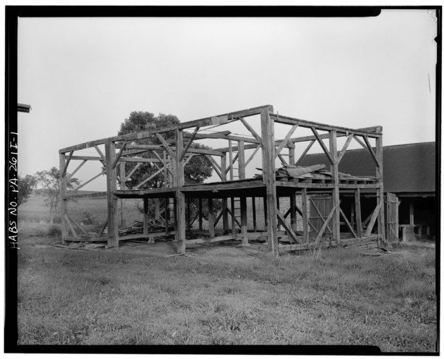 Pre-Civil War barn frames in a grassy field.