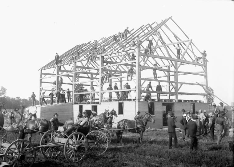 John Boyd, Public domain, via Wikimedia Commons A black and white photo of a barn being built