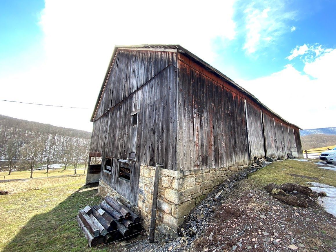 Weathered barn with stone foundation for barn to house conversion cost.