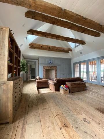 Rustic Living Room with Exposed Wooden Beams and Stone Fireplace in Pennsylvania
