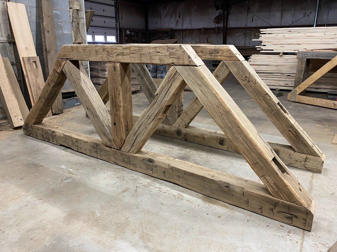 Wooden truss structure in a workshop, highlighting barn frame dismantling.