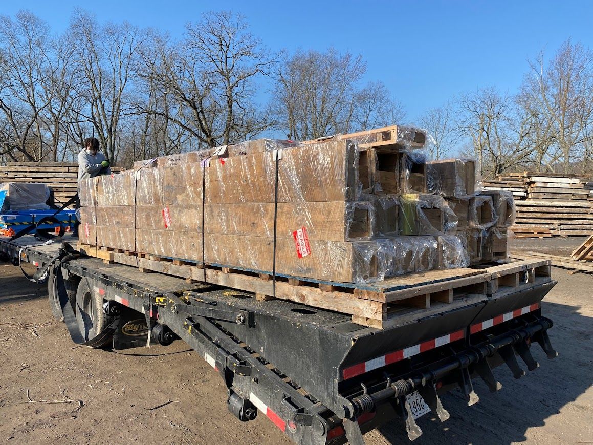 Flatbed truck loaded with antique barn frame delivery.