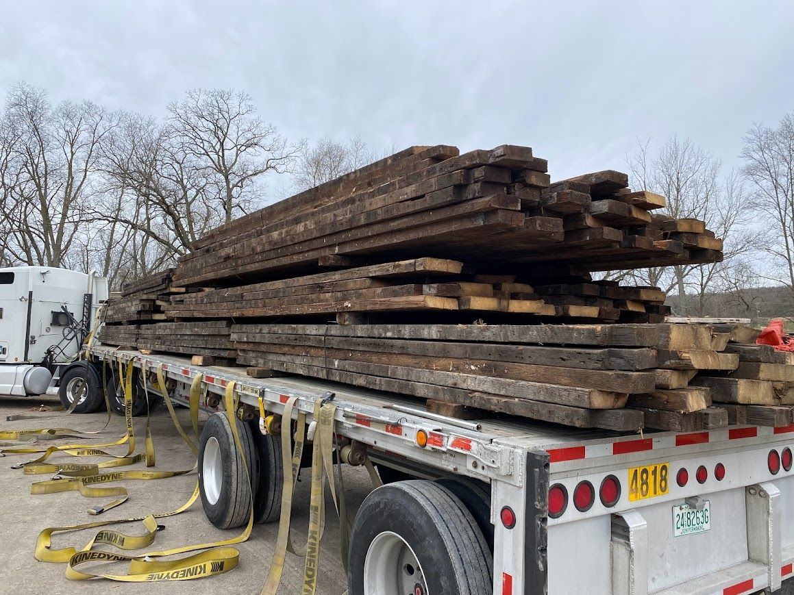Flatbed trailer loaded with planks for timber recycling.