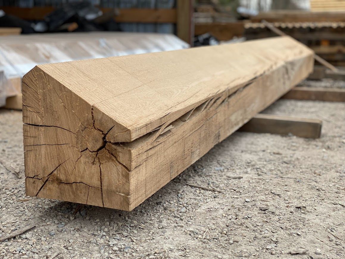Rough-hewn wooden beam with visible splits in timber.