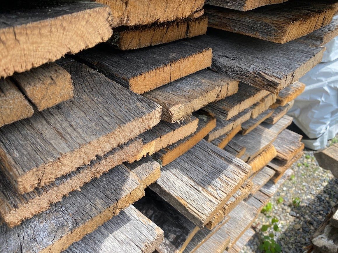 A stack of weathered planks highlights types of reclaimed wood.