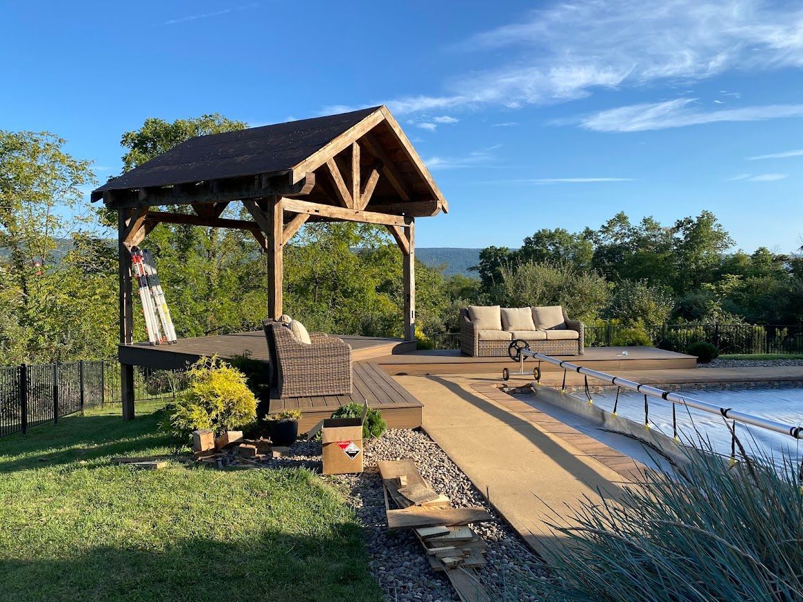 Gazebo with antique barn wooden beams by a pool.