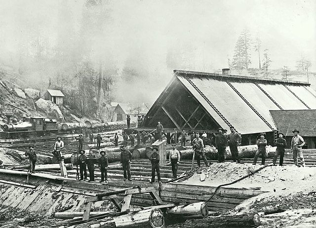 Workers at a sawmill showcasing historic architecture.