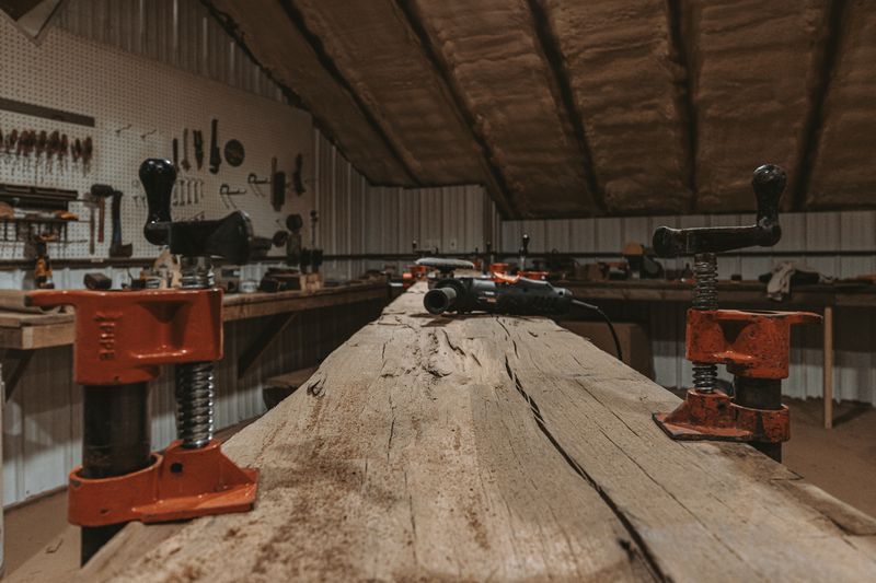 Wooden workbench with tools and splits in timber.