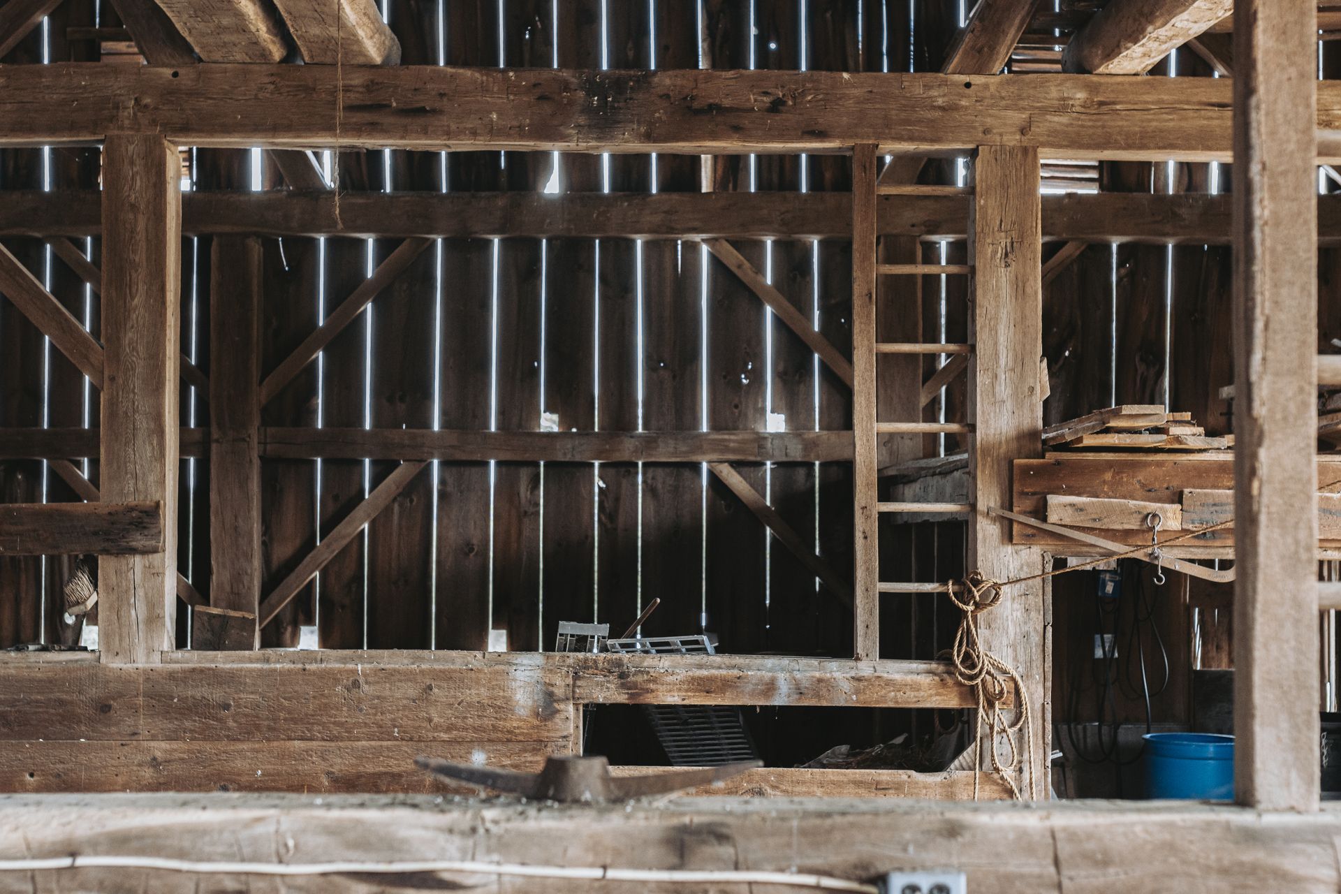 The inside of an old wooden barn with a ladder