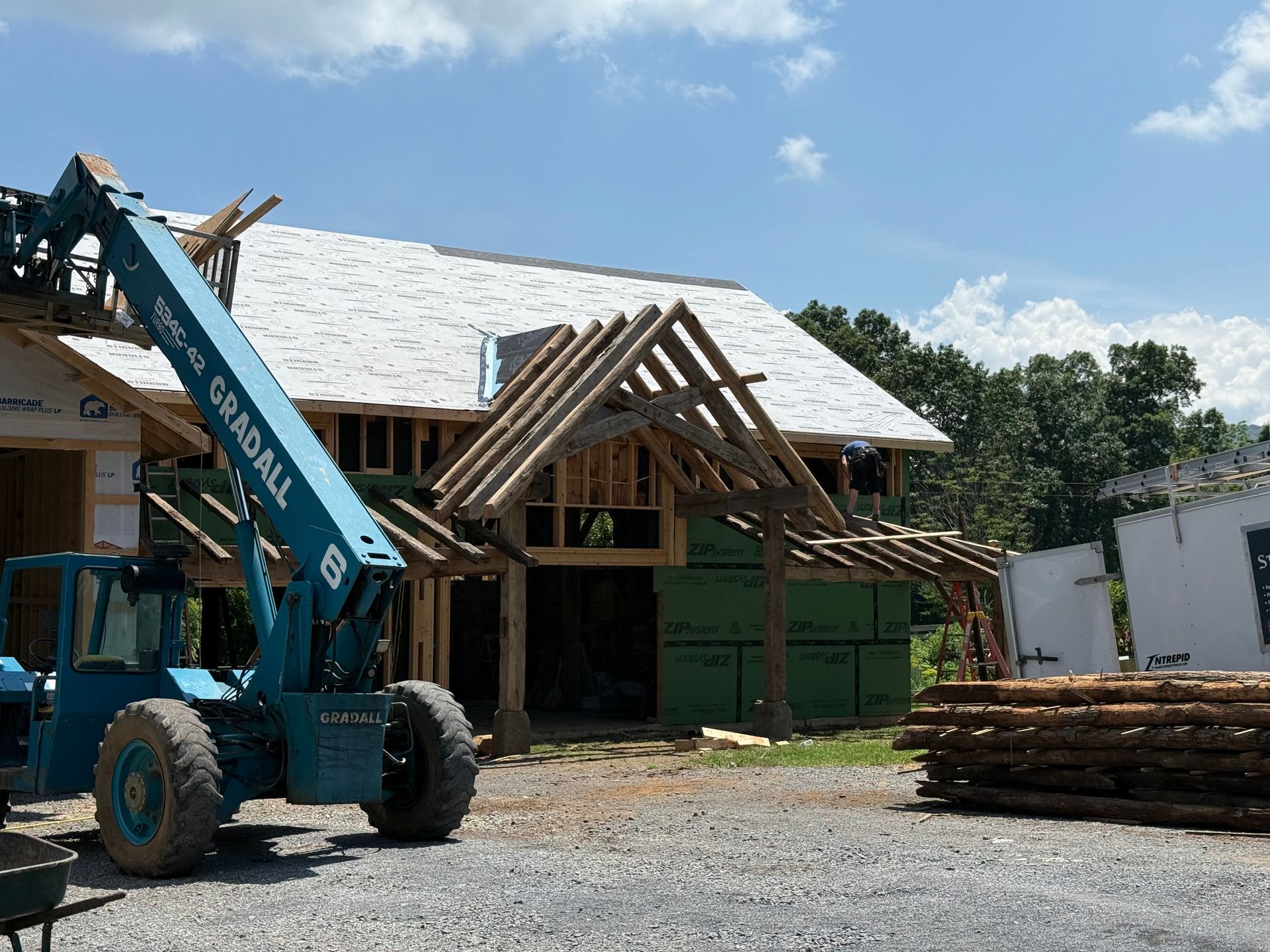 House under construction with timber porch and telehandler, illustrating how much do barn conversions cost during builds.