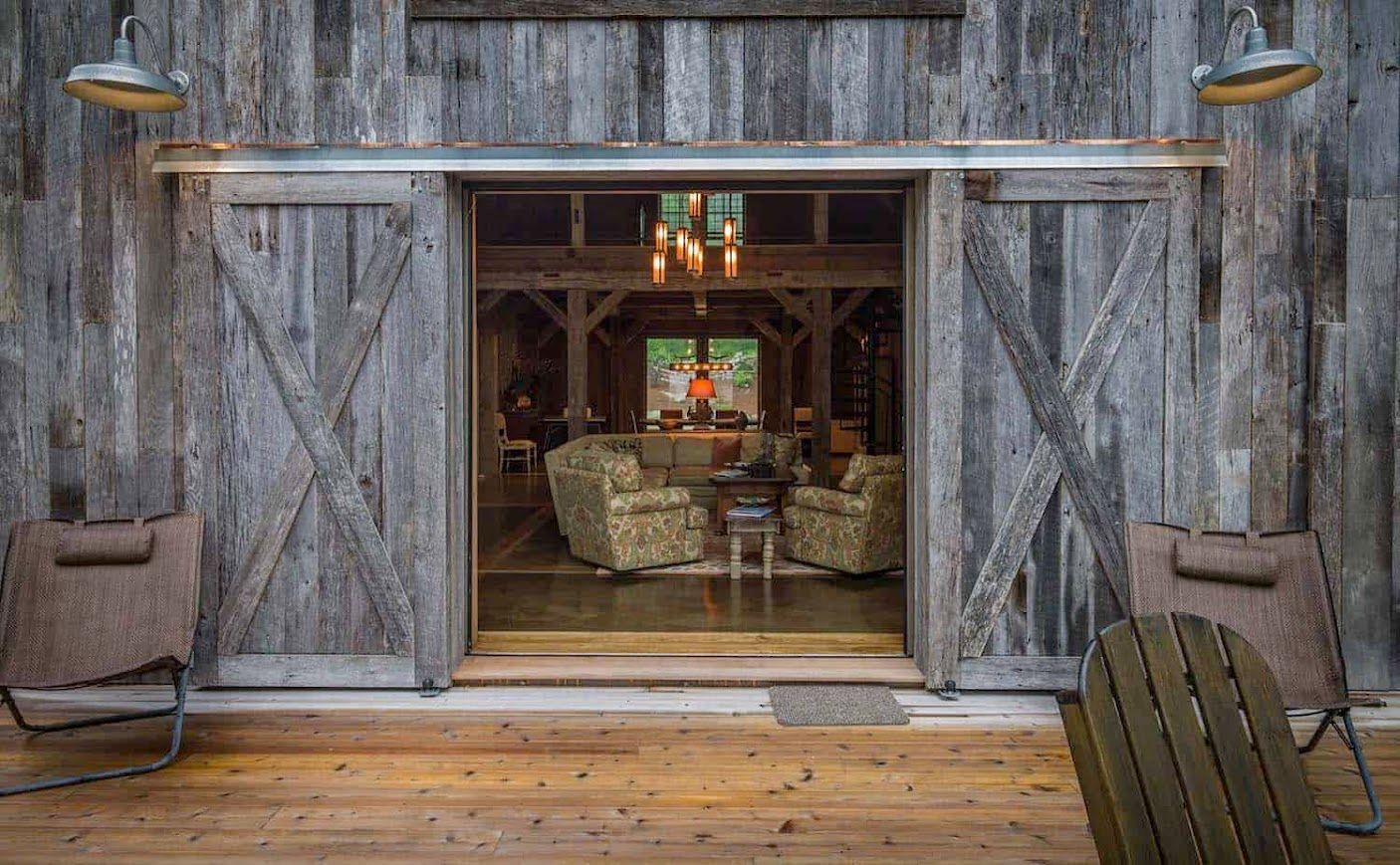 Rustic barn door opening to a cozy barndominium interior.