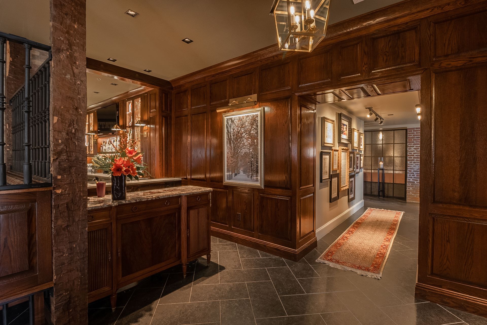  A refined ranch style house design with elegant interior,  dark wood paneling, arched doorway, and warm lighting, 