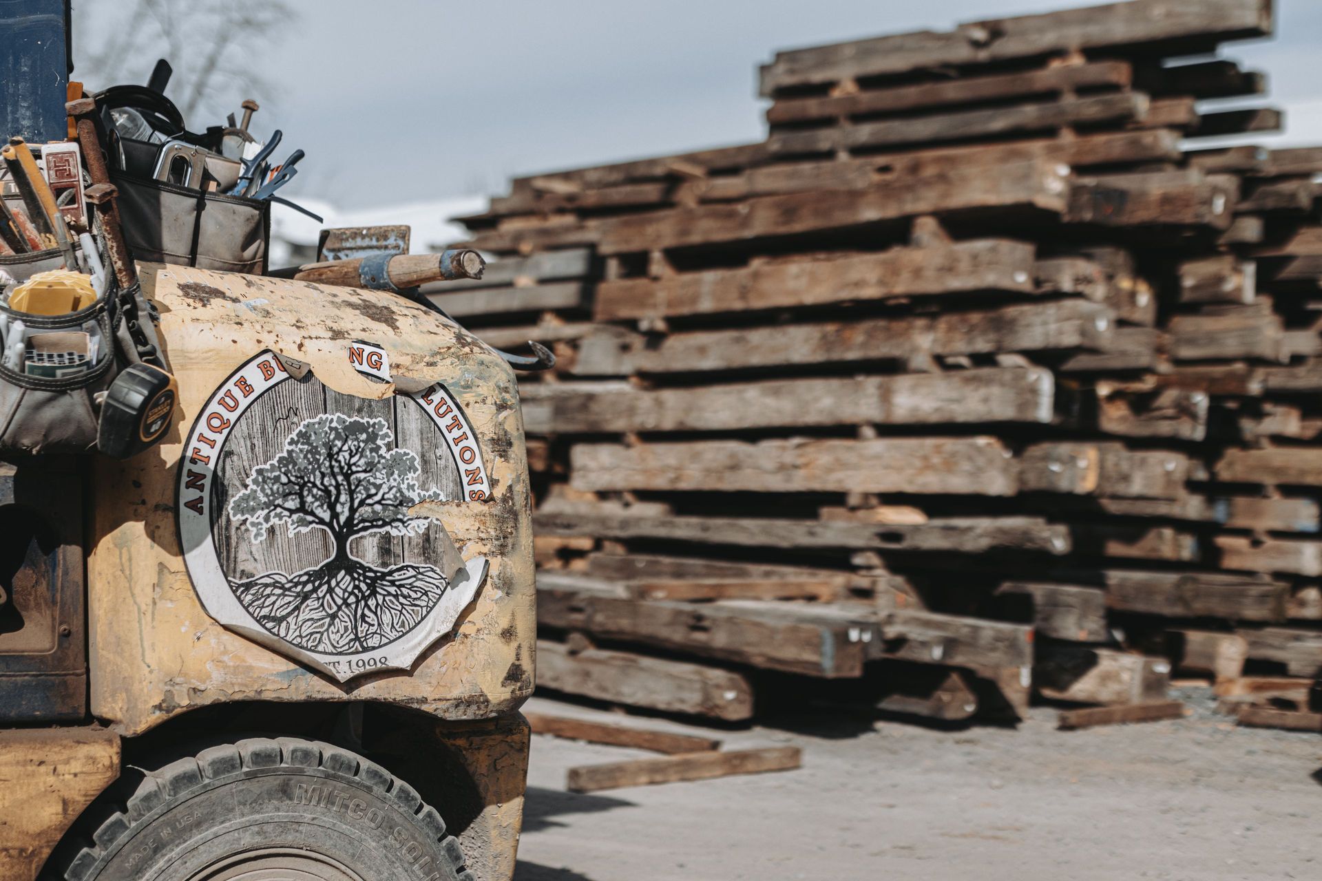 Forklift with reclaimed wood beams for sustainable building materials.