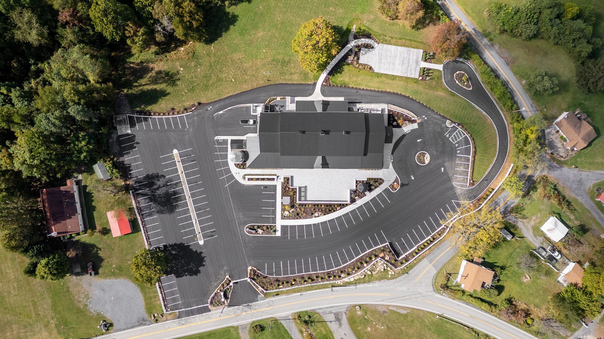 Aerial view of a modern building and parking lot, suggesting historic barn event venue conversions.